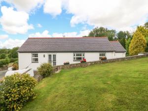 Casa blanca con un gran patio verde en Bwthyn Clai, en Llangefni