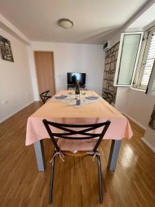 a dining room table with a pink table cloth on it at Apartman Aterina in Korčula