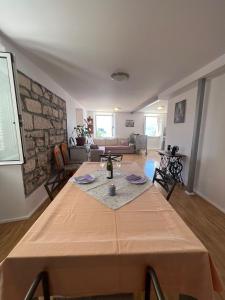 a table in a living room with a stone wall at Apartman Aterina in Korčula
