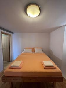 a bed with two pillows on it in a room at Apartman Aterina in Korčula