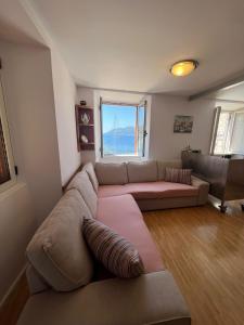 ein Wohnzimmer mit einem großen Sofa und einem Fenster in der Unterkunft Apartman Aterina in Korčula