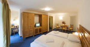 A bed or beds in a room at Dolomitenhotel Weisslahnbad