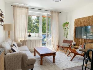 een woonkamer met een bank en een tafel bij Erzgebirge Suite Bergruhe in Kurort Oberwiesenthal