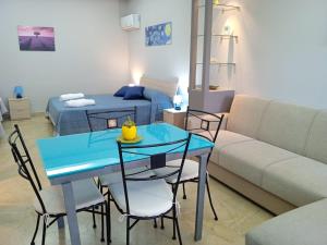 a living room with a blue table and a couch at Bougainvillea casa vacanza in Castelbuono