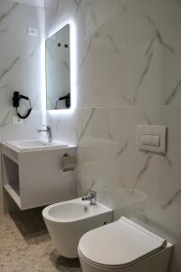 uma casa de banho com um lavatório, um WC e um espelho. em David's Studio Stays em Vlorë