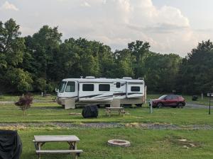 a rv parked in a field with a picnic table at Chigger Hill RV Park in Hatfield