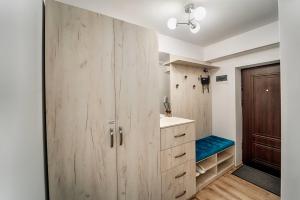 a bathroom with wooden cabinets and a blue bench at Apartament Bacovia in Bacău +32 photos
