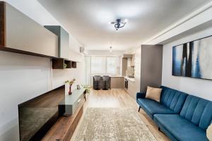 a living room with a blue couch and a kitchen at Apartament Bacovia in Bacău