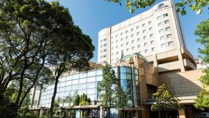 a large white building with trees in front of it at Hotel Port Plaza Chiba in Chiba