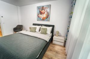 a small bedroom with a bed and a chair at Apartament Bacovia in Bacău