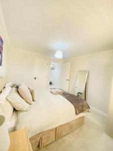een slaapkamer met een groot bed met witte lakens en kussens bij Vileto apartment in central Bournemouth in Bournemouth