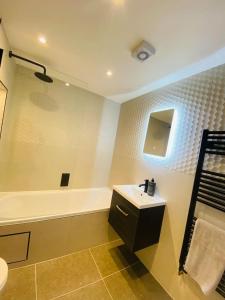 a bathroom with a sink and a bath tub at Vileto apartment in central Bournemouth in Bournemouth