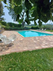 - une piscine avec 2 chaises et une table dans l'établissement Casolare della Quiete, à Corridonia