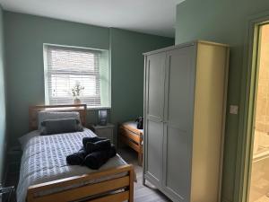 een slaapkamer met een bed, een kast en een raam bij The Angel Inn in Troed-y-rhiw