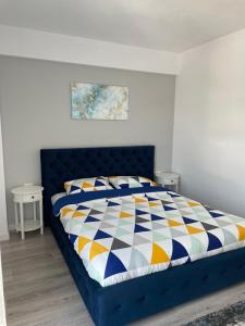 ein Schlafzimmer mit einem blauen Bett mit einer bunten Bettdecke in der Unterkunft Apartament - Housing21 in Gura Humorului