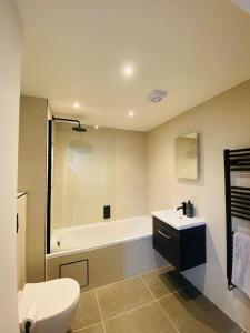 a bathroom with a tub and a toilet and a sink at Vileto apartment in central Bournemouth in Bournemouth