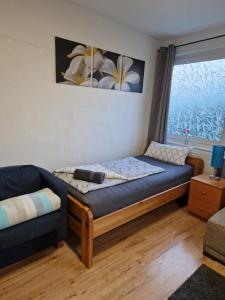 a bed in a room with a couch and a window at Sweet Home Sarstedt in Sarstedt