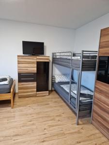 a room with two bunk beds and a television at Sweet Home Sarstedt in Sarstedt