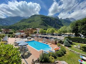 un resort con piscina e montagne sullo sfondo di Chalet al Lago a Molveno