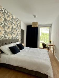 Un dormitorio con una gran cama blanca y una ventana en Apartament przy plaży Willa Redłowo, en Gdynia