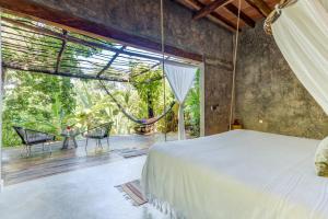 - une chambre avec un lit et une grande fenêtre dans l'établissement Casitas Maraika, à Puerto Vallarta