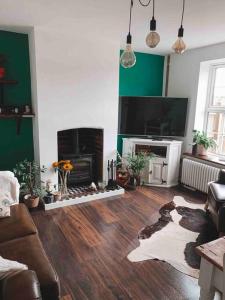 a living room with a couch and a fireplace at Victorian quirky farm cottage next to forest & close to beach in Woodbridge