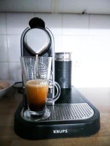 a coffee maker with a cup of coffee on a table at Victorian quirky farm cottage next to forest & close to beach in Woodbridge