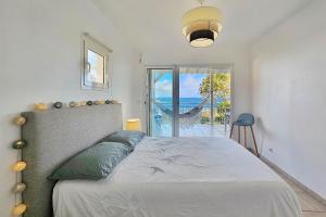 a bedroom with a bed with a view of the ocean at Appartement Carpe Diem in Le Moule
