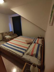 a bedroom with a bed with a striped blanket at Apartments Erenda in Fuškulin