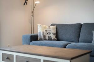 a blue couch in a living room with a throw pillow at Alte Waescherei _9462_ in List