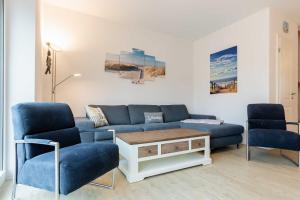 a living room with a blue couch and two chairs at Alte Waescherei _9462_ in List