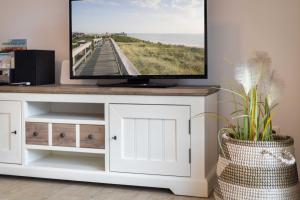 a television on top of a white entertainment center at Alte Waescherei _9462_ in List