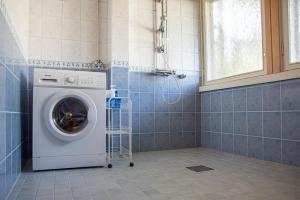 uma máquina de lavar roupa na casa de banho com uma janela em Omakotitalo keskustan lähellä em Joensuu
