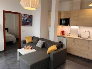 Una sala de estar con un sofá y una cocina. en Málaga La Bella centro histórico, en Málaga