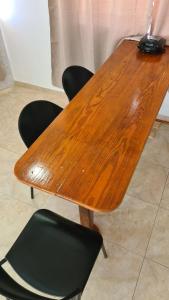 a wooden table with chairs and a lamp on top at Janeth’s Place Apartamento in San Andrés