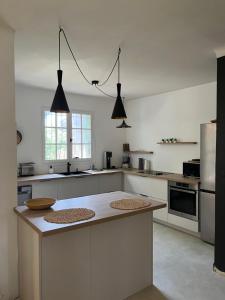 a kitchen with white cabinets and a island in it at Le Verger in Aix-en-Provence