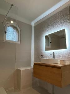 La salle de bains est pourvue d'un lavabo, d'un miroir et d'une douche. dans l'établissement Le Verger, à Aix-en-Provence