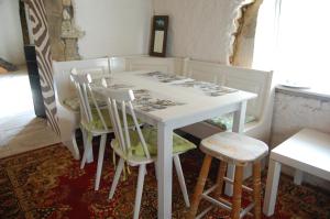 a white table with four chairs in a room at Gite Juste Confortable in Fleurey-lès-Lavoncourt