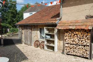 a small building with a pile of fire wood at Gite Juste Confortable in Fleurey-lès-Lavoncourt