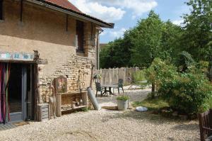a stone building with a bench in front of it at Gite Juste Confortable in Fleurey-lès-Lavoncourt