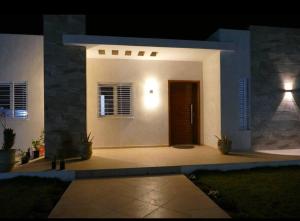 a white house with a door at night at Villa Shams - with Pool in Mellita