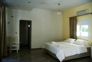 a bedroom with a large white bed and a window at Antonios Hotel Apartments in Matala