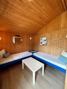 um quarto com duas camas e uma mesa em Løken Camping - trivelig og idyllisk ved vannet em Olden