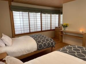 una camera con due letti e una finestra di Kihachikan North Nozawa Onsen a Nozawa Onsen