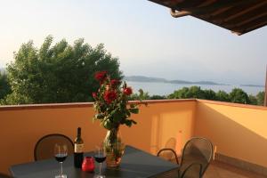 a vase of flowers on a table with wine glasses at Residence Miralago Rooms & Apartments in Manerba del Garda