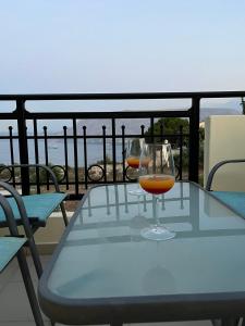 a glass of wine sitting on a table on a balcony at Όμορφο διαμέρισμα με θέα in Korakiaí