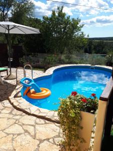 une piscine avec un toboggan orange et un radeau orange dans l'établissement Casa Deborah, à Ripenda Kras
