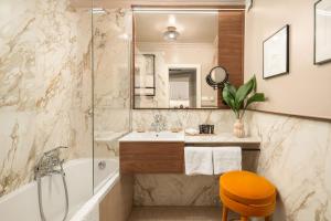 a bathroom with a tub and a sink and a mirror at Queen's Court Hotel & Residence in Budapest