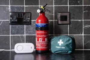 a red fire hydrant next to a first aid kit at Large 4 Bed Ideal for Contractors - Free Parking in Bedford