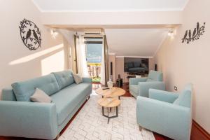 Apartment Ena with amazing sea view في كوتور: غرفة معيشة مع كنبتين زرقاوين وطاولة